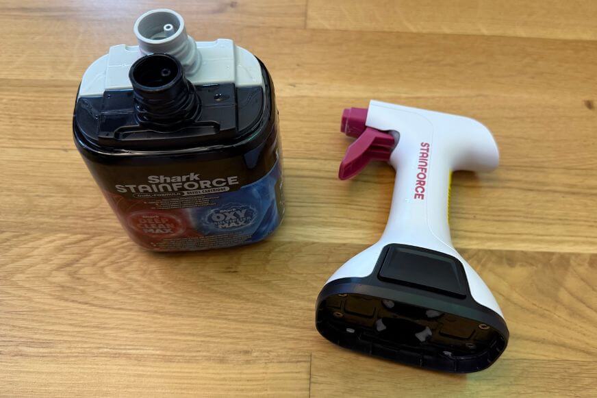 Die originale Shark Reinigungslösung für den Stainforce ist zu sehen und die Sprühflasche die Du aufstecken kannst steht daneben.